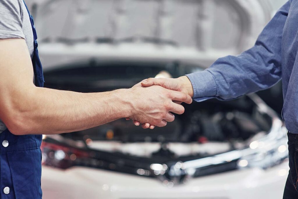 mecánico de automóviles y cliente llegan a un acuerdo sobre la reparación del automóvil